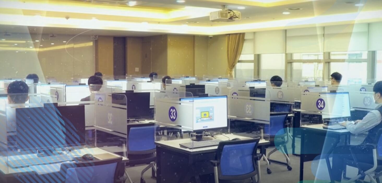ICT자격본부 소개화면, 컴퓨터가 설치된 시험장 내부에서 수험자들이 컴퓨터를 사용 중 이미지